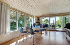 een kamer met een tafel, stoelen en ramen bij Gorgeous Home In Fars With Kitchen in Farsø