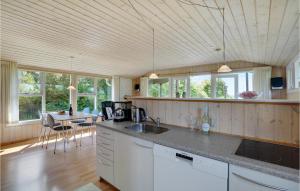 een keuken met een aanrecht en een tafel met stoelen bij Gorgeous Home In Fars With Kitchen in Farsø