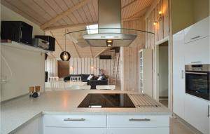 uma cozinha com um balcão e uma sala de estar em Nice Home In Glesborg With 4 Bedrooms, Sauna And Wifi em Bønnerup Strand