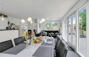 a dining room and living room with a table and chairs at Pet Friendly Home In Vinderup With Sauna in Vinderup