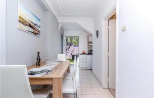 Stunning Apartment In Kostrena With Kitchen في كوسترينا: مطبخ مع طاولة خشبية ودواليب بيضاء