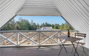a table and chair on a screened in porch with a window at Holiday Home Thadesvej Rømø X in Toftum +26 photos