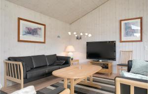 a living room with a couch and a tv at Stunning Home In Lkken With 5 Bedrooms, Sauna And Wifi in Løkken