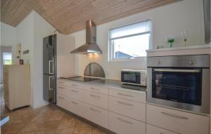 a kitchen with a refrigerator and a microwave at Holiday Home Nordbakken Ebeltoft Vi in Ebeltoft