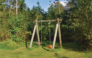 a swing in a field with a ball on it at Holiday Home Lyngshuse Herning V in Kølkær