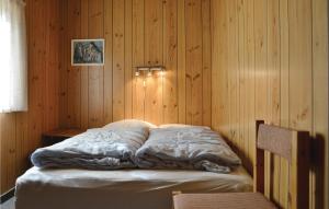 Cama en habitación con pared de madera en Stunning Home In Herning With Kitchen en Kølkær