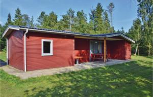 een rode hut met een patio in een veld bij Stunning Home In Herning With Kitchen in Kølkær