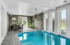 ジルレジェにあるBeautiful Home In Gilleleje With Indoor Swimming Poolのダイニングルーム付きの家のスイミングプール