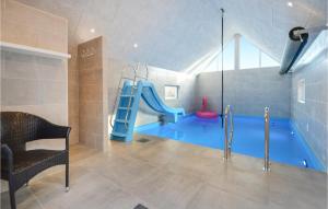 uma sala de jogos com um escorrega e uma piscina em Nice Home In Rm With Kitchen em Toftum