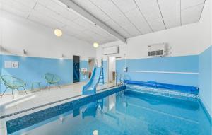 ein Schwimmbad mit Rutsche in einem Gebäude in der Unterkunft Amazing Home In Hemmet With Sauna in Hemmet