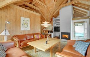ein Wohnzimmer mit einem Sofa und einem Tisch in der Unterkunft 4 Bedroom Cozy Home In Hvide Sande in Havrvig