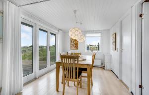 una sala da pranzo con tavolo, sedie e finestre di Holiday Home Fanø 54 a Sønderho