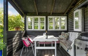 um pequeno alpendre com uma mesa branca e cadeiras em Nice Home In Tisvildeleje With Kitchen em Tisvildeleje