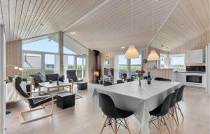 a dining room and living room with a table and chairs at Awesome Home In Haderslev With 3 Bedrooms, Wifi And Sauna in Flovt