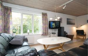 uma sala de estar com um sofá e uma mesa em Awesome Home In Hadsund With Sauna em Haslevgårde