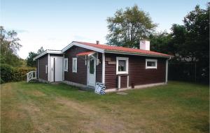 una pequeña casa en un patio con un campo de hierba en Awesome Home In Hadsund With Sauna en Haslevgårde
