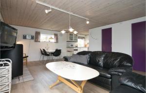 HaslevgårdeにあるBeautiful Home In Hadsund With 2 Bedrooms, Sauna And Wifiのリビングルーム(黒い革張りのソファ、テーブル付)