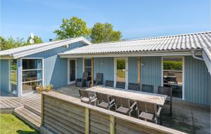 a deck with chairs and a table on a house at Stunning Home In Juelsminde With Wifi in Sønderby
