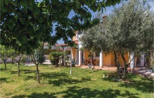 a house with a yard with trees in front of it at Nice Apartment In Kastel With Kitchen in Kaštel