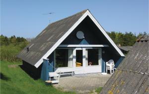 a small house with a black roof and a white door at Awesome Home In Glesborg With 3 Bedrooms And Wifi in Bønnerup Strand