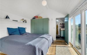 a bedroom with a bed with blue pillows at Stunning Home In Fanø With Kitchen in Fanø +23 photos