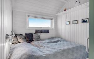 a bed in a small room with a window at Stunning Home In Fan With Kitchen in Fanø