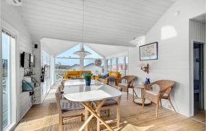 a dining room with a white table and chairs at Beautiful Home In Fan With 3 Bedrooms, Sauna And Wifi in Fanø