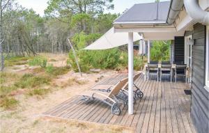 una terraza con mesa, sillas y sombrilla en Stunning Home In lbk With Wifi, en Ålbæk