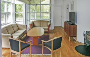 uma sala de estar com um sofá, uma mesa e cadeiras em Rubinsen Skovhuse em Hasle