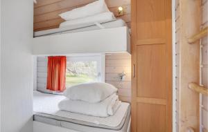 um pequeno quarto com almofadas brancas e uma janela em 2 Bedroom Gorgeous Home In Hadsund em Hadsund