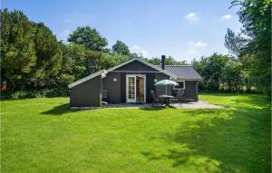 a small shed with an umbrella in a yard at Amazing Home In Humble With Sauna in Humble