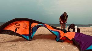 two people working on a kite on the beach at Blue Whale Resort & Kite Surfing in Kalpitiya