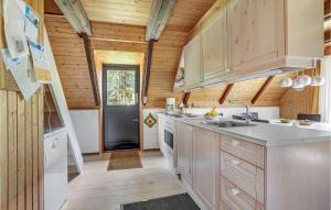 cocina con paredes de madera y suelo de madera en Two-Bedroom Holiday Home In Blavand, en Blåvand