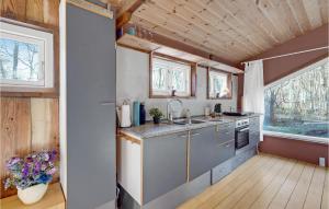 eine Küche in einem winzigen Haus mit Fenstern in der Unterkunft Lovely Home In Stege With Kitchen in Stege