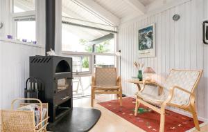 Øster HurupにあるAwesome Home In Hadsund With 3 Bedrooms, Sauna And Wifiのリビングルーム(薪ストーブ、椅子付)