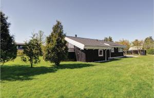 una casa en un campo con un patio de hierba en Stunning Home In Hadsund With Kitchen, en Øster Hurup