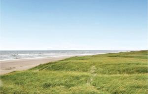 ein Strand mit grünem Gras und dem Meer in der Unterkunft Three-Bedroom Holiday Home In Harboore in Harboør