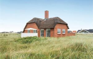 ein altes Backsteinhaus auf einem Rasen in der Unterkunft Three-Bedroom Holiday Home In Harboore in Harboør