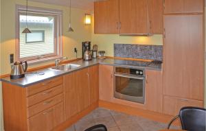 a kitchen with wooden cabinets and a sink and a window at Amazing Home In Mesinge With House Sea View in Mesinge