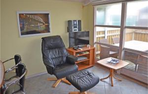 a living room with a chair and a television at Amazing Home In Mesinge With House Sea View in Mesinge