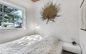 a white bedroom with a bed and a window at Holiday Home Midtvej Nexø Iv in Balke +12 photos