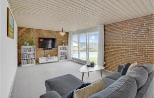 sala de estar con sofá y pared de ladrillo en Beautiful Home In Krus With Kitchen, en Kruså