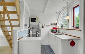 a kitchen with white cabinets and a window at Holiday Home Gedser Feriepark Gedser Vi in Gedser