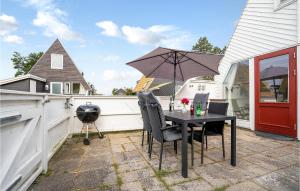 a table and chairs with an umbrella on a patio at Beautiful Home In Gedser With 2 Bedrooms And Wifi in Gedser