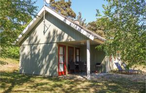 a small green cottage with a red door at 3 Bedroom Stunning Home In Aakirkeby in Vester Sømarken +9 photos