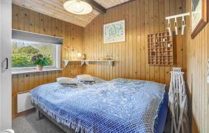 a bedroom with a blue bed in a wooden wall at Nice Home In Sydals With 3 Bedrooms, Sauna And Wifi in Skovby