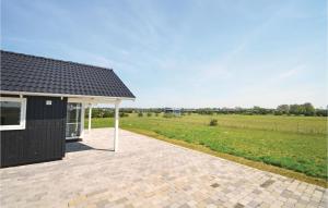 a black house with a white roof and a field at 3 Bedroom Lovely Home In Vggerlse in Marielyst