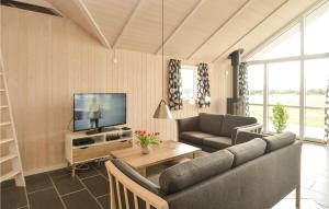 a living room with a couch and a tv at Three-Bedroom Holiday Home In Vaggerlose in Marielyst +12 photos