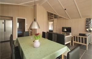 a dining room with a table with a vase of flowers on it at Three-Bedroom Holiday Home In Vaggerlose in Marielyst
