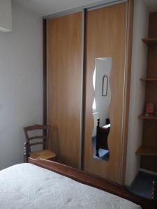 - une chambre avec une porte coulissante et une chaise à côté d'un lit dans l'établissement Le Moulin des Prés, à Vesoul
